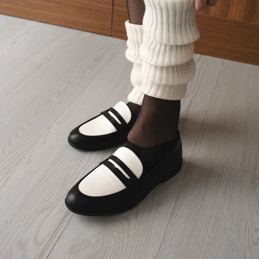Women’s two-tone black and white flat shoes in elegant loafer style, made from premium vintage faux leather, perfect for both formal and casual looks.