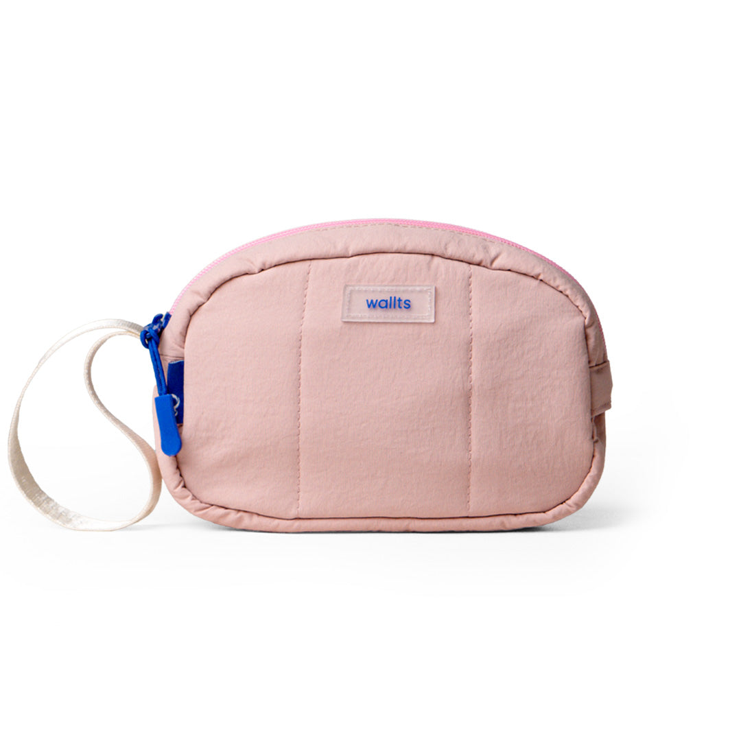 A peach Muuji pouch with a blue wristlet strap, made from water repellent nylon material, with a label showing the brand Wallts.