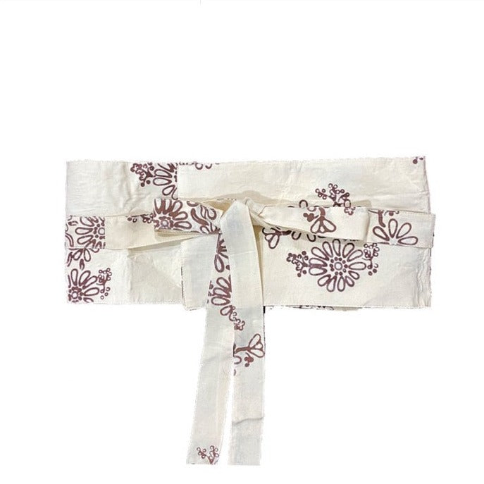 A traditional ivory Obi Belt with a floral pattern in brown, made of rayon, tied in a bow.