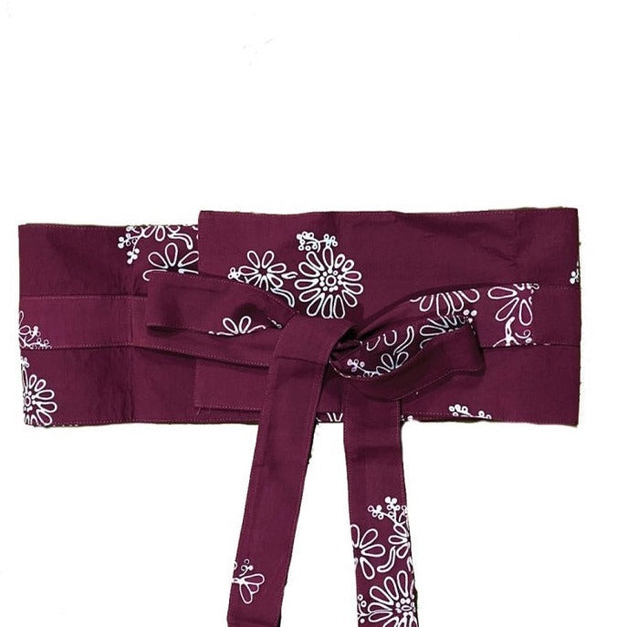 A traditional maroon Obi Belt with a floral pattern in brown, made of rayon, tied in a bow.