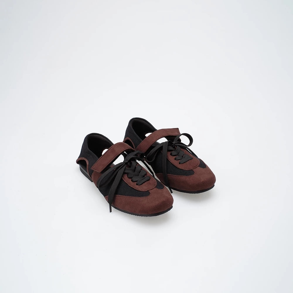 Pair of brown and black flat shoes on a white background