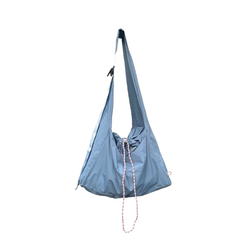 Light blue drawstring crossbody bag by Measure Pleasure with a strap on a white background