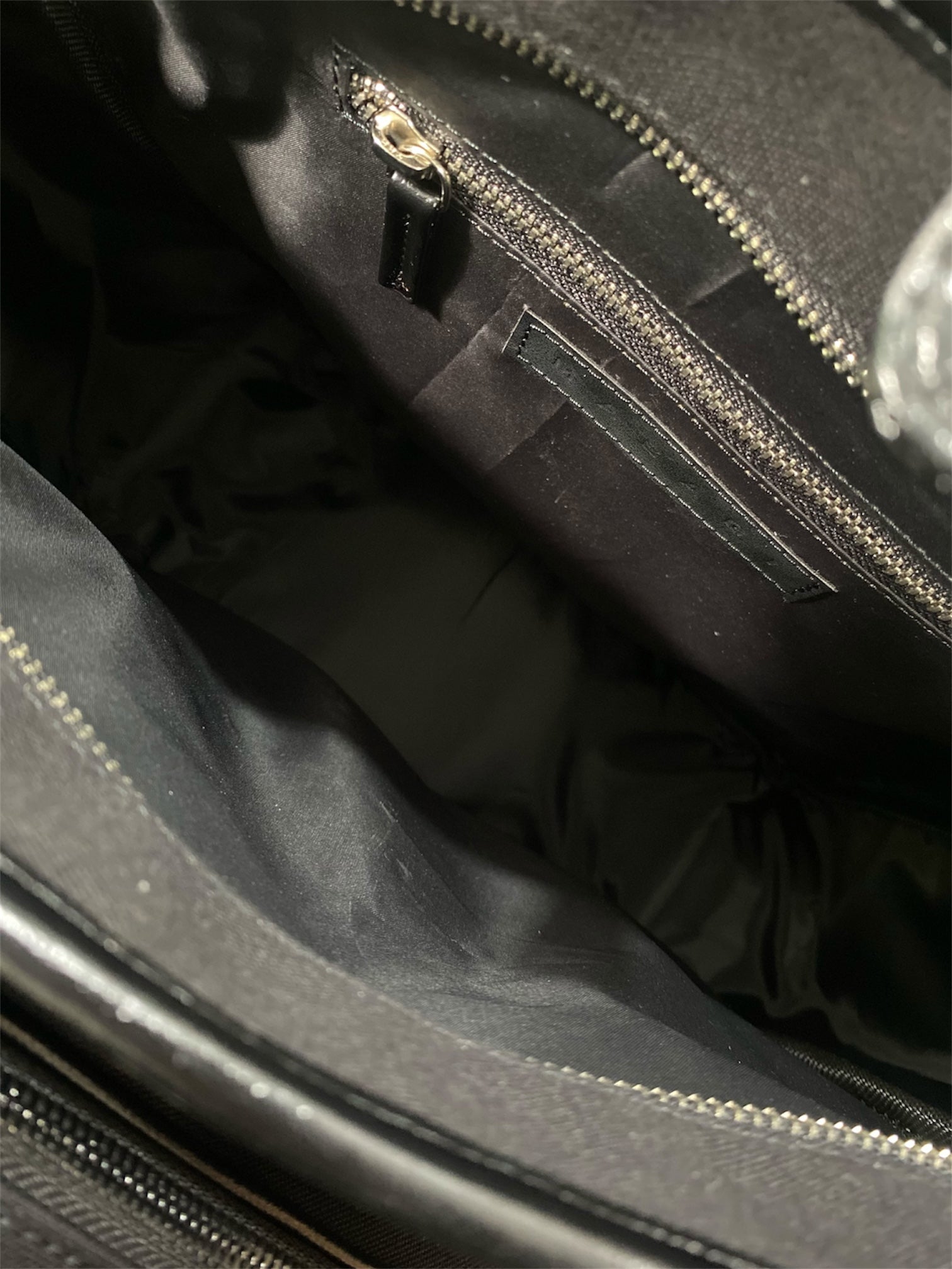 Close-up of a black padel handbag with a zipper