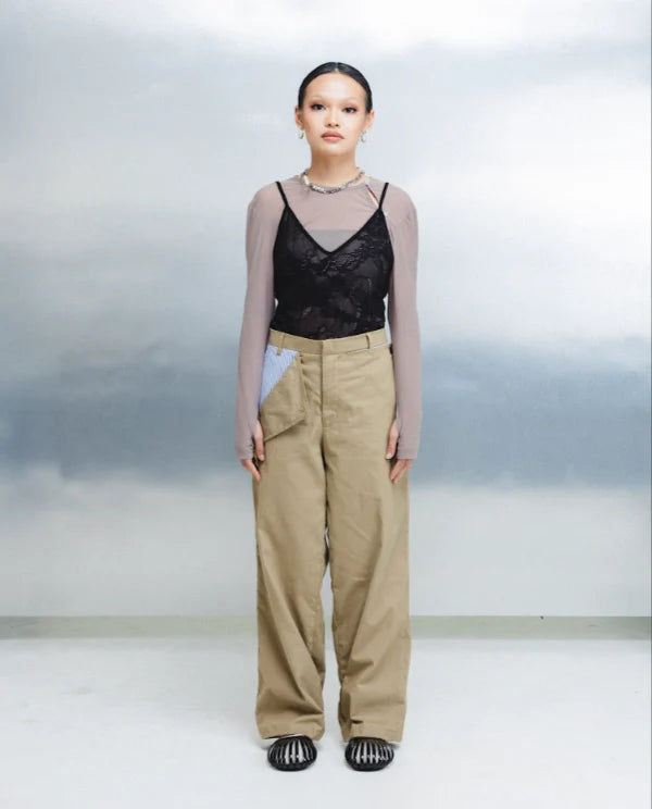 Model wearing a black lace top and brown utility pants by Wad Studio against a plain background