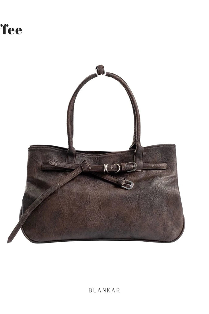 Brown leather women's handbag with a strap on a white background.

Tas wanita berbahan kulit cokelat dengan tali, berlatar belakang putih.