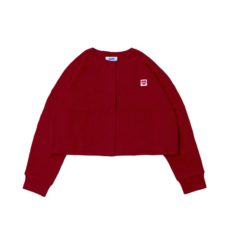 A red cardigan with long sleeves, a round neckline, and front pockets laid out flat by notyourcompany on a plain background.