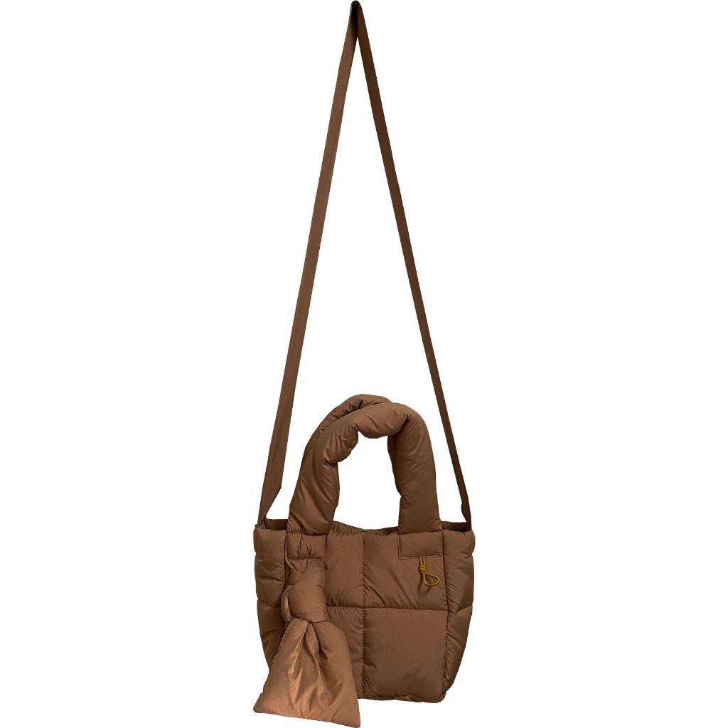 A brown nylon sling bag by Hunting Fields with a button closure and a detachable strap.