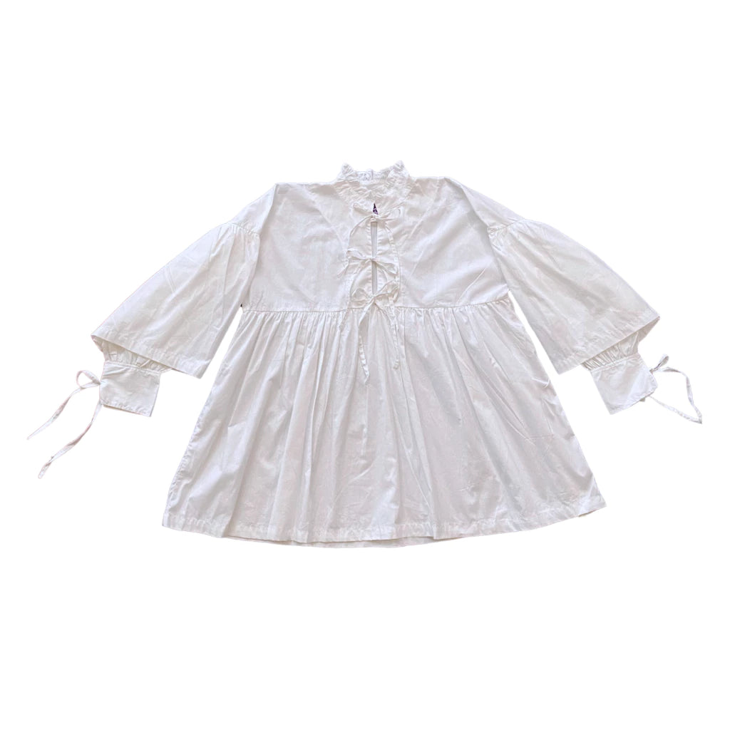 White blouse by Tuff Puff with lace details on a white background