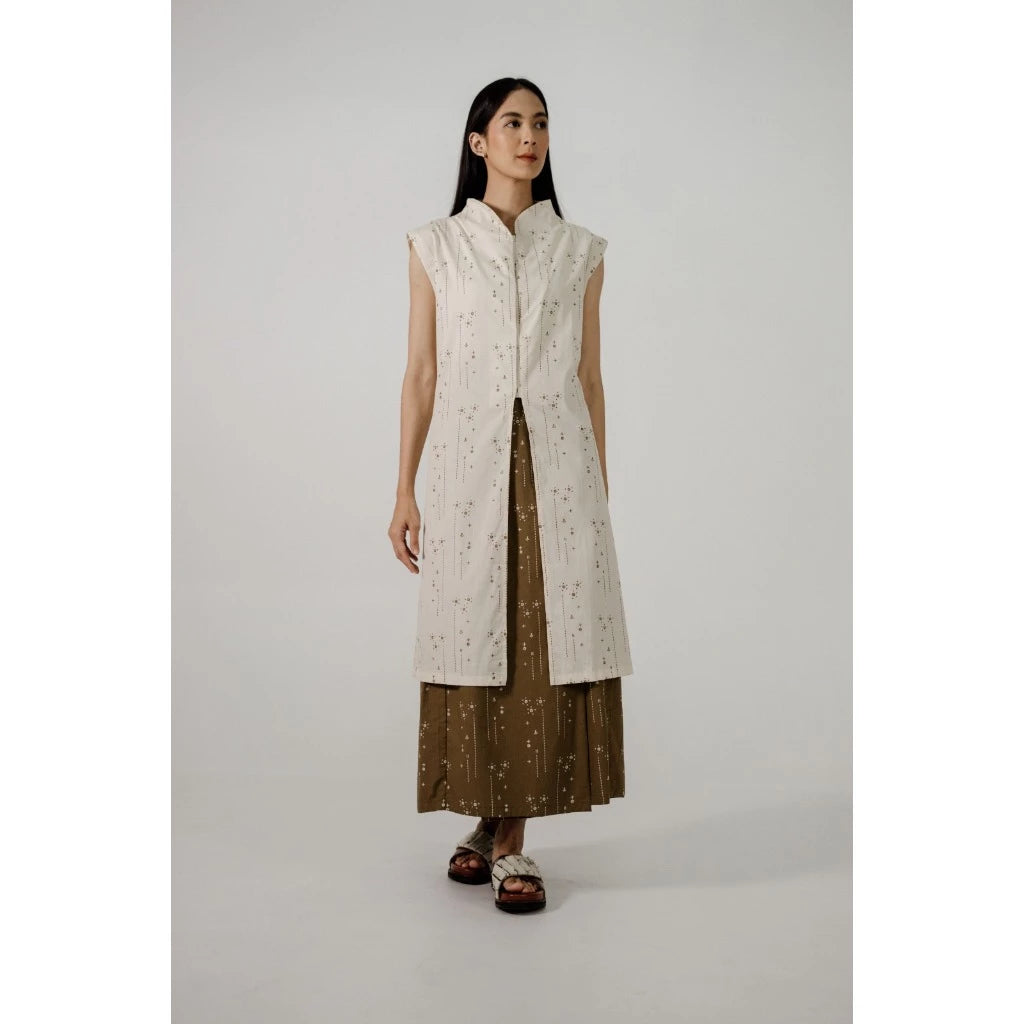 Woman wearing a long cream kebaya by Damakara with a patterned skirt on a plain background

Seorang wanita mengenakan kebaya panjang lengan pendek berwarna krem dari Damakara dengan rok bermotif di atas latar belakang polos