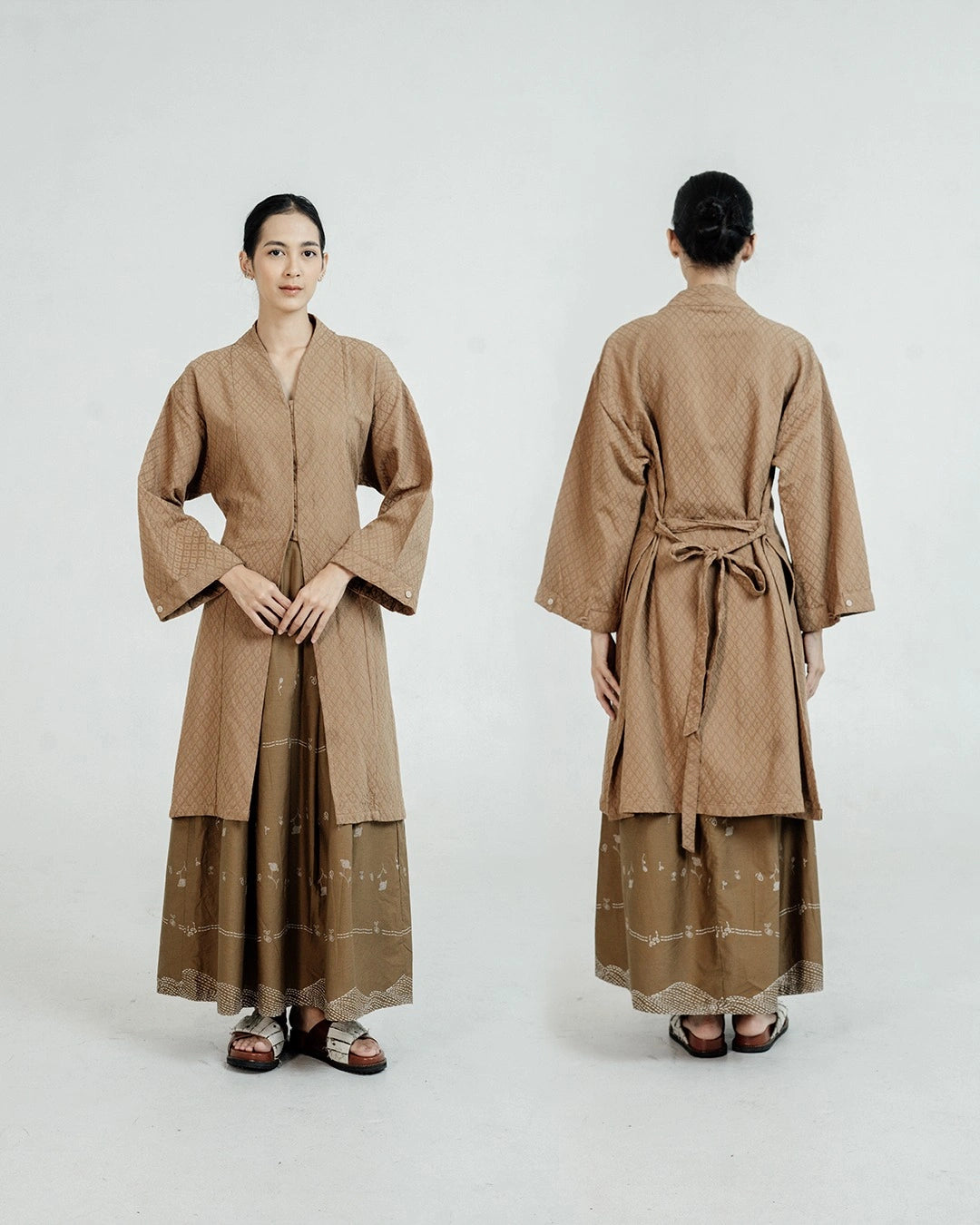 Woman wearing a long brown tunic by Damakara with a belt, shown from front and back on a white background.
