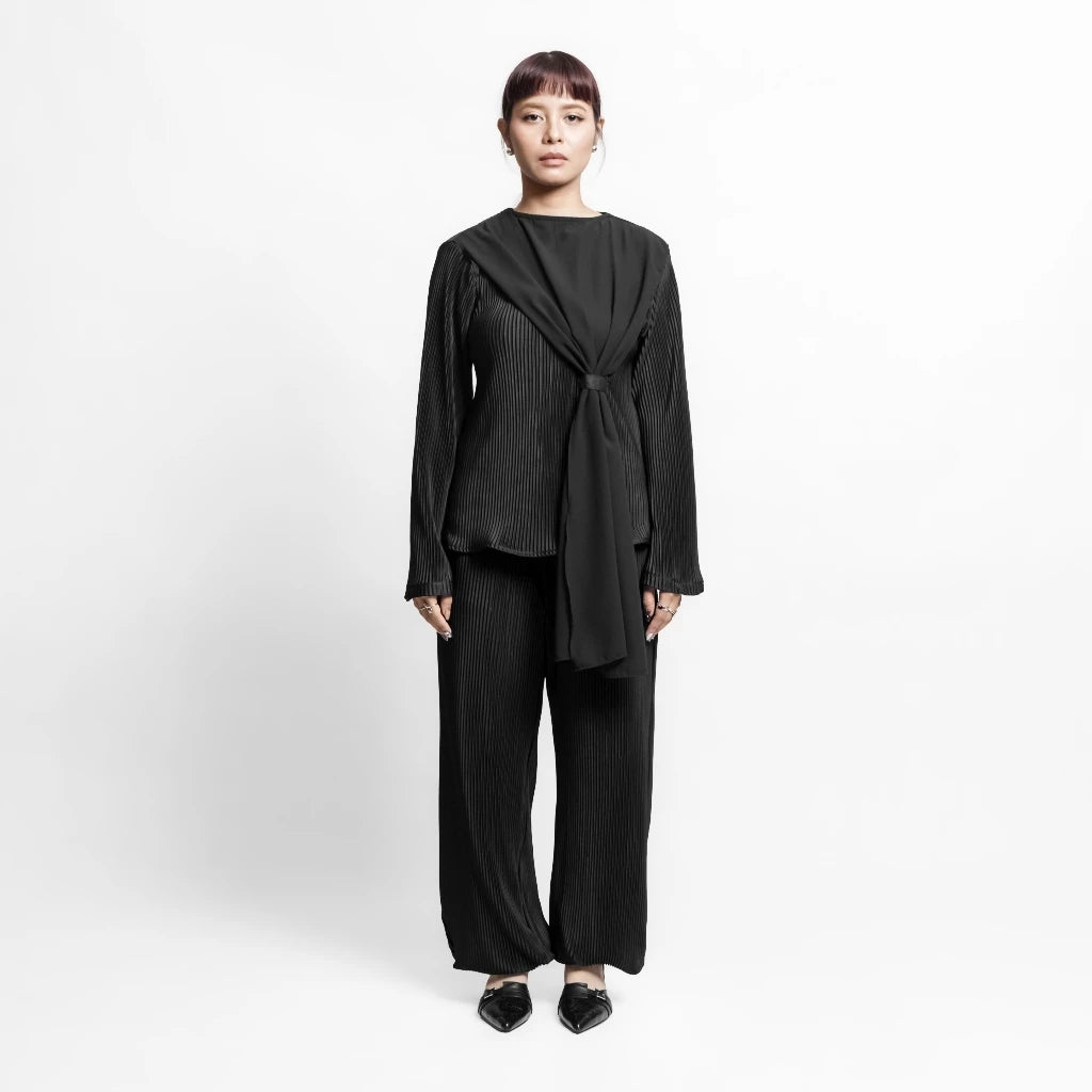 Woman wearing a black outfit by Isoos Studios on a white background