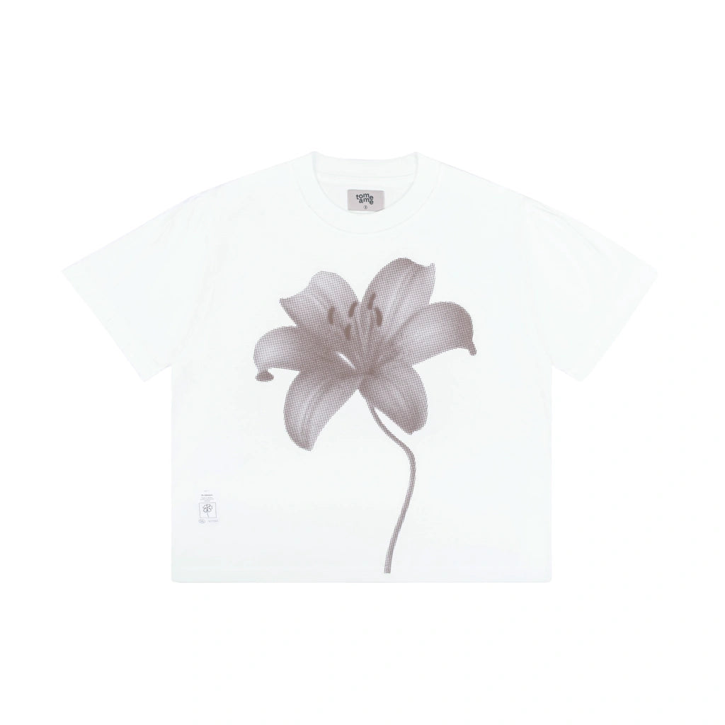 A white short-sleeve crewneck t-shirt  by Tome Ame featuring a large, detailed grayscale lily flower graphic printed on the front, displayed against a solid white background.