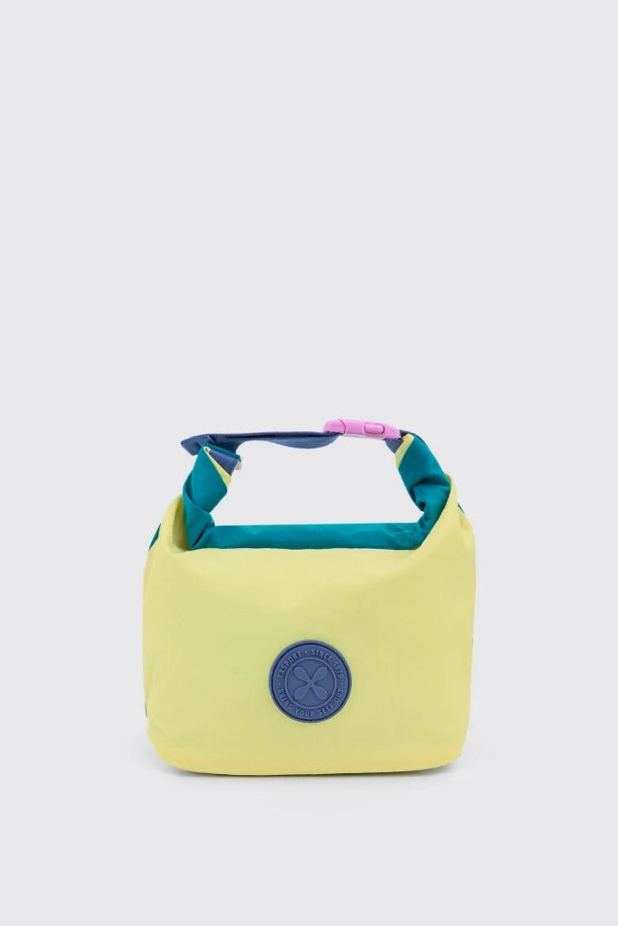 A yellow insulated lunch bag by Exsport Bag with a teal handle, a pink accent, and a blue circular logo patch on the front, set against a light gray background.