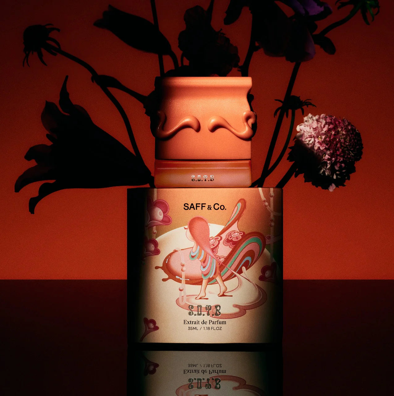 SAFF & Co. S.O.T.B perfume bottle with decorative label against a red background