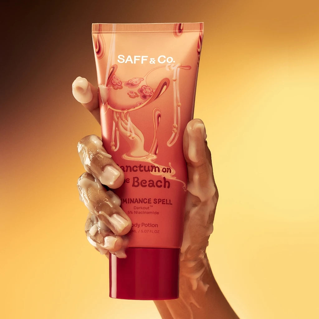 A person's hand holding a tube of Saff n Co body lotion 'Sanctum on the Beach'.