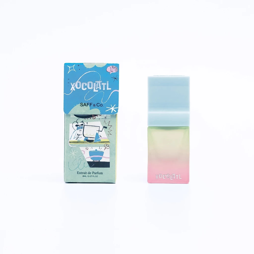 A travel size bottle of Saff & Co. Extrait De Parfum - Xocolatl, with a colorful packaging featuring illustrations.