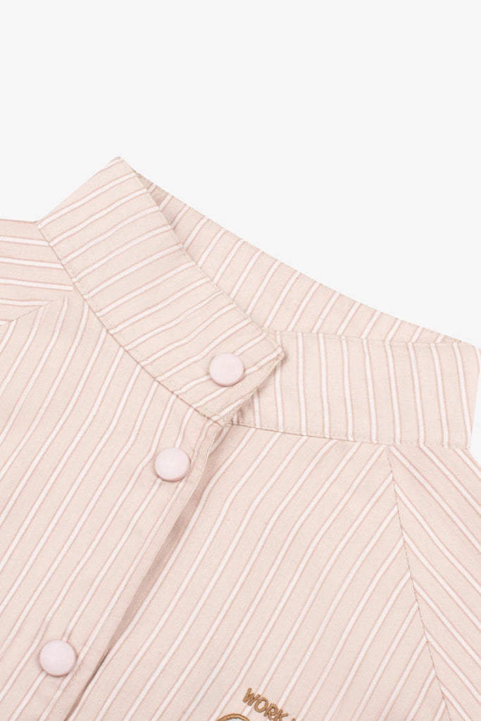 Close-up of a light pink and white vertically striped button-down jacket collar by Tome Ame with pale pink buttons, on a white background.
