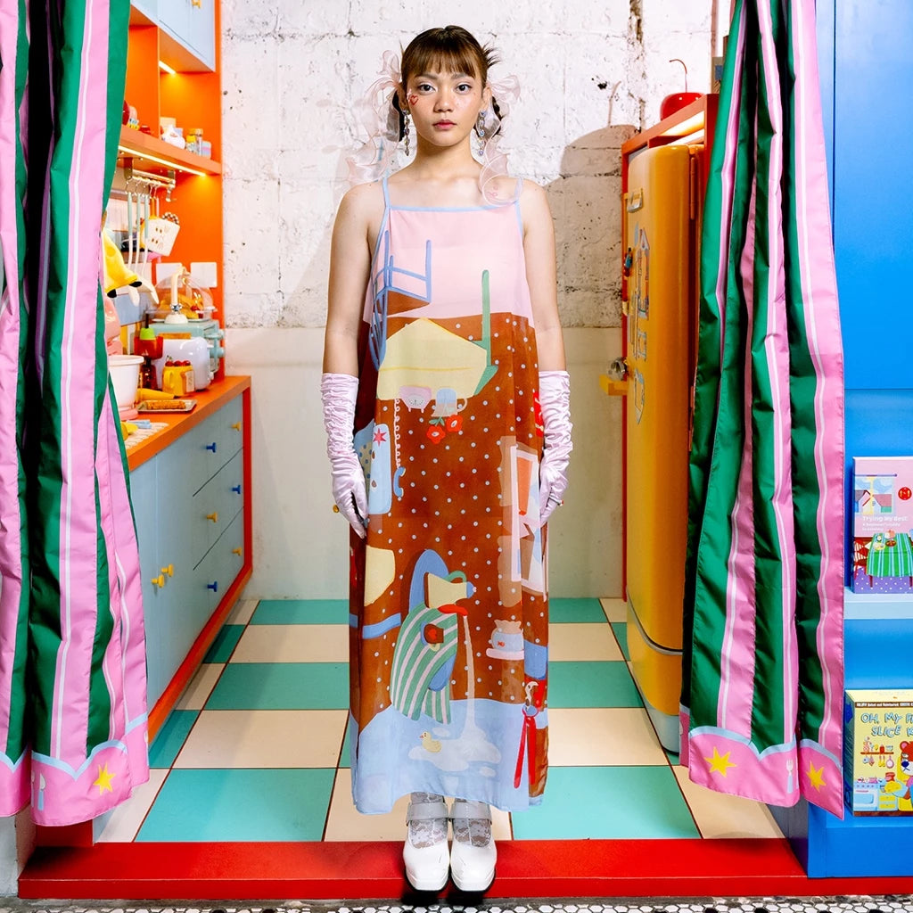 Person wearing a colorful see through dress by Oh.Irv with abstract designs in a vibrant, multicolored room.